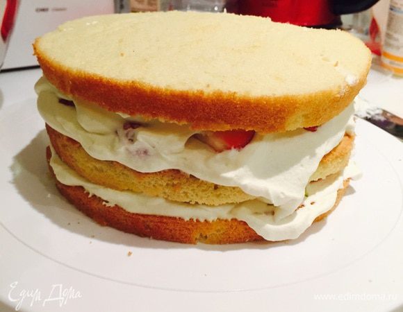 Клубничку опять покрываем кремом и накрываем вторым коржом, верхней частью бисквита. Повторяем процедуру с кремом и клубникой. Накрываем третьим коржом (который у нас был серединкой).