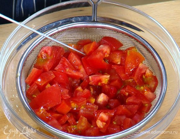 Помидоры нарезать небольшими кубиками, поместить в дуршлаг и дать соку стечь.