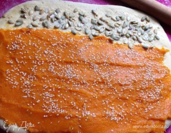 Раскатать тесто в прямоугольник, почти квадрат (чтобы пирог получился высоким, рулет должен быть не длинным, а толстым).
Если используете сухую начинку (мак, кунжут) — смажьте тесто маслом.
Я на 2/3 распределила тыквенное пюре (у меня была очень сладкая тыква - сахар я не добавляла) и посыпала кунжутом, а 1/3 смазала растительным маслом, посыпала сахаром, кунжутом и очищенными тыквенными семечками. Сделала так для того, чтобы при выпечке тыквенное пюре не вылезло из разрезов. Влажную начинку, при желании, можно присыпать 1 ст. л. крахмала.