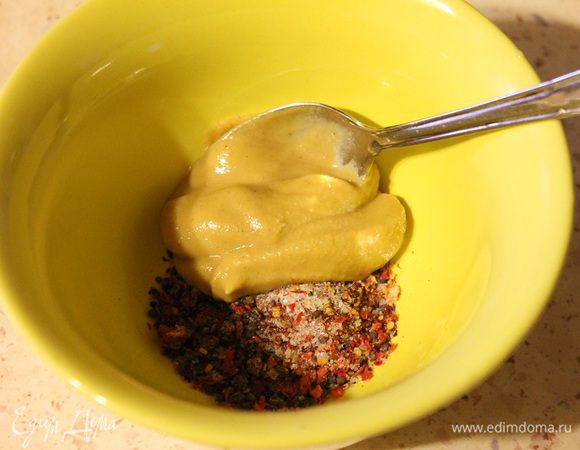 Свинину нашпиговать чесноком. Семена кардамона, розовый перец, острый перец и семена горчицы измельчить в ступке, туда же добавить соль и горчицу, перемешать. 