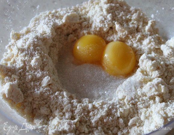 Муку с маслом перетереть руками в крошку. Добавить желтки, воду, сахар и соль.