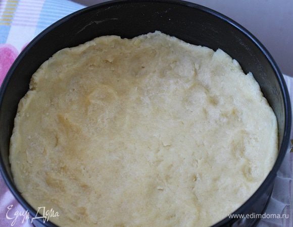 Тесто раскатать толщиной не более 1 см и выложить в форму для выпечки. Сверху застелить пергаментом и насыпать груз (подойдут сухая фасоль и горох). Выпекать основу в духовке при температуре 200 градусов, 25 минут.