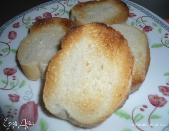 Багет порезать на кусочки и поджарить в тостере. Сбрызнуть оливковым маслом. 