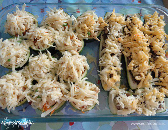 Выложить начиненные цукини в жаропрочную форму. Присыпать сверху сыром.