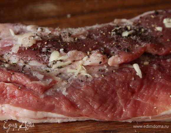 Разворачиваем его, солим, перчим по вкусу, рубим ножом чеснок и натираем им наш кусок.