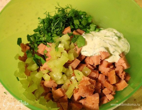 Сосиски и перец болгарский нарезать мелкими кубиками, добавить мелко рубленную зелень и сметану. Перемешать.