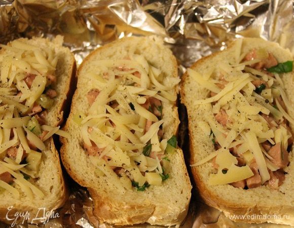 Оставшийся сыр натереть на крупной терке и посыпать им бутерброды. Выпекать в заранее разогретой до 190 градусов духовке, до тех пор, пока сыр сверху не расплавится.