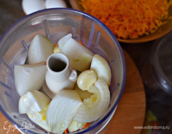 Лук и чеснок очистите от шелухи. Нарежьте лук на крупные куски и вместе с чесноком измельчите с помощью измельчителя. Можно лук также натереть и на мелкой тёрке, а чеснок пропустить через пресс.
