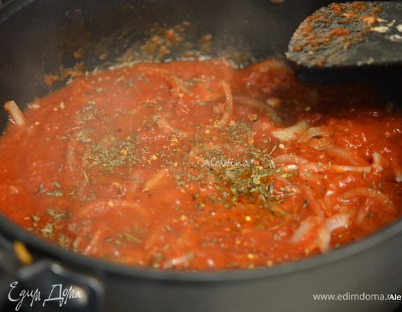 Добавить томаты (мелко порезанные) баночные в соку, специи прованские, красный перец хлопьями. Закрыть крышкой и тушить 15 минут.