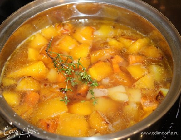 Переложите тыкву в кастрюлю, добавьте к ней картофель, тимьян и влейте овощной бульон. Доведите до кипения и варите 15-20 минут, пока картофель не станет мягким.