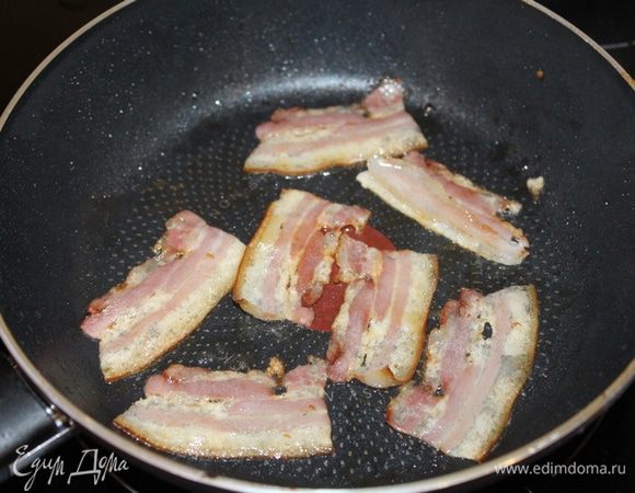 На сухой сковороде обжарьте кусочки бекона.
