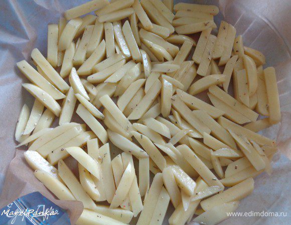 Выложим картошку в один слой в жаропрочную форму, застеленную бумагой для выпечки.