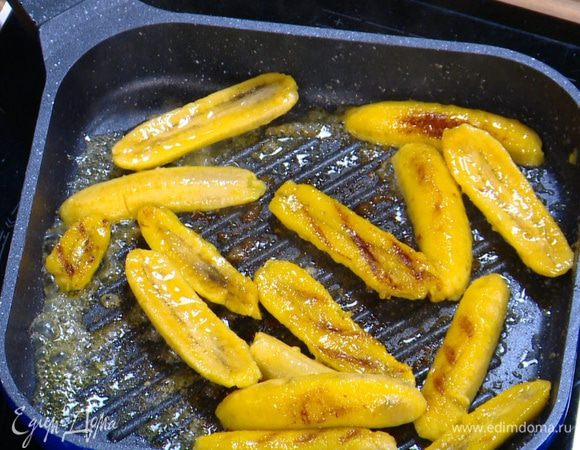 Разогреть сковороду-гриль и обжаривать половинки бананов до появления карамельных полосок, затем переложить на тарелку.