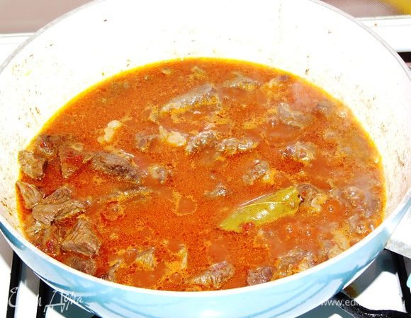 Далее добавляем чуть меньше стакана кипятка и продолжаем тушить. У меня не оказалось томатов в собственном соку, поэтому я сначала добавила к мясу пол ложки томатной пасты, быстро обжарила, а потом залила кипятком. Тушим мясо до мягкости около часа. 

Сразу оговорюсь, что в некоторых рецептах советуют сразу засыпать все овощи и тушить вместе с мясом. На мой взгляд, это хорошо, если тушить все в духовке, в горшочке для тушения, например. Иначе я не сторонник этого пути, потому что за час овощи превращаются в кашу и лук переваривается. Поэтому сначала тушим просто мясо.