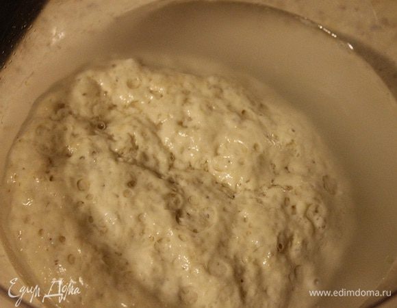 Закваска будет слегка пахнуть кислотой, удвоится в объеме и будет иметь пористую структуру. В большой миске залить водой закваску и размешать.