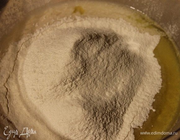 Добавить муку, масло и соль и снова перемешать. Затем вымесить тесто в течение 13-15 минут на слегка посыпанной мукой поверхности пока тесто не станет гладким и эластичным.