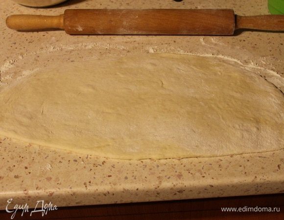 Разделить тесто на 2 равные части. Берем одну часть теста, выкладываем на посыпанную мукой поверхность и раскатываем в прямоугольник.