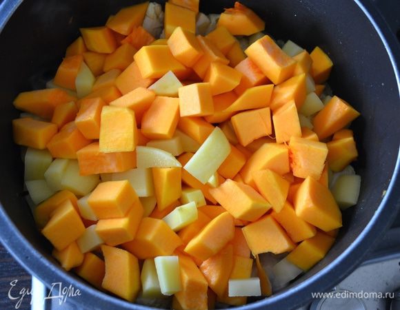 Следом добавить тыкву и картофель. Влить бульон (или горячую воду) и тушить до готовности, примерно 15-17 минут.