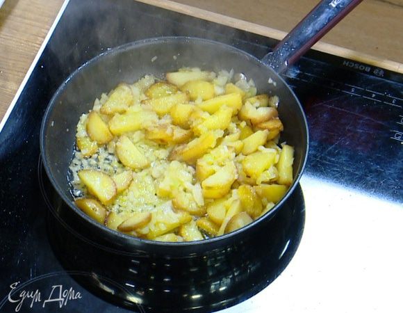 В сковороду с картофелем добавить лук, все перемешать, посолить, поперчить и обжарить.