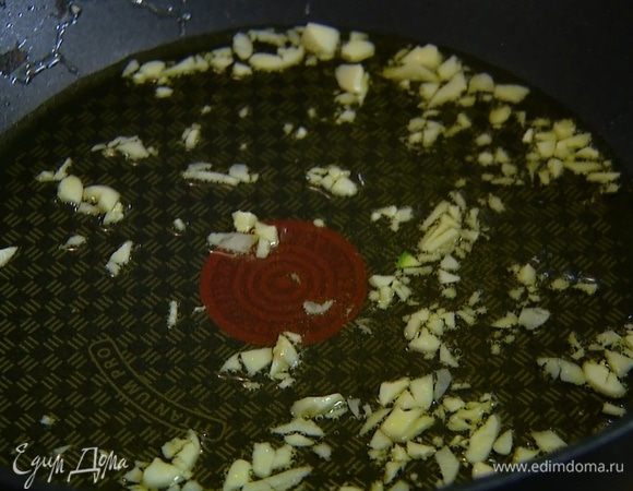 Разогреть в тяжелой глубокой сковороде 2 ст. ложки оливкового масла и обжарить чеснок до прозрачности.