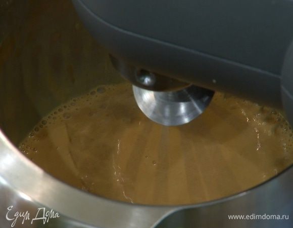 В чашу комбайна влить молоко, добавить 1 1/2 банки вареного сгущенного молока и взбить все насадкой-венчиком в густую карамельную массу.