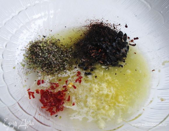 Соединить в большой миске два вида масла, добавить специи и чеснок, пропущенный через пресс. Посолить по вкусу.