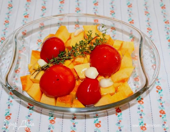 Тыкву очистить и нарезать на кусочки, положить в форму, туда же отправить помидоры, чеснок и тимьян. Полить все оливковым маслом и отправить в духовку.