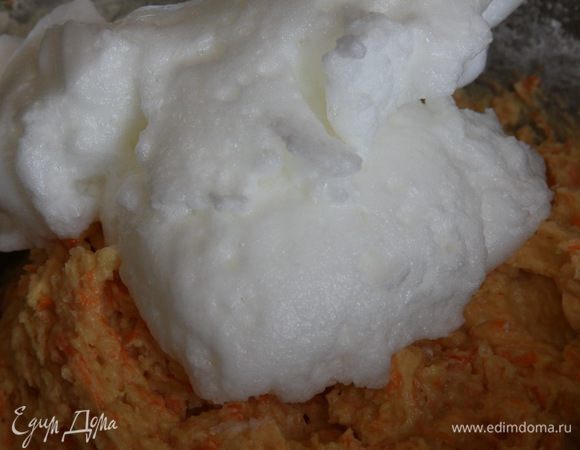 Теперь пришло время взбитых белков. Сначала добавляем приблизительно половину и аккуратно вмешиваем в тесто.