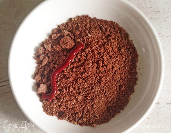 Высыпаем шоколадный грунт в тарелку для подачи.

Достаем готовое желе из холодильника. Обдаем стенки емкости теплой водой (так желе будет проще достать).

Берем по одной трубочке и, нажимая на них с одного конца, выдавливаем готовых червячков на грунт.