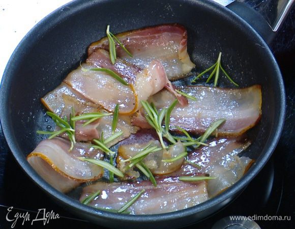 Разогреть отдельную сковороду, обжарить сало с двух сторон до золотистого цвета, затем добавить листья розмарина и еще немного обжарить.