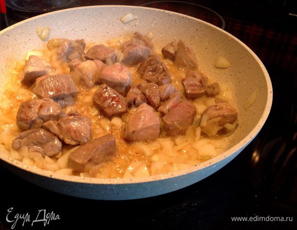Обжарьте мясо на раскалённом оливковом масле. Добавьте лук и жарьте ещё 5 минут на среднем огне.