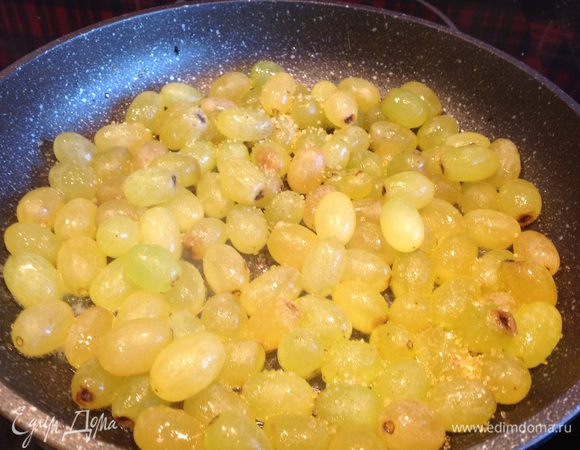 Виноград вымойте, отделите ягоды от веточки. Положите в кипящее масло, присыпьте сахаром и готовьте на сильном огне около 5 минут.