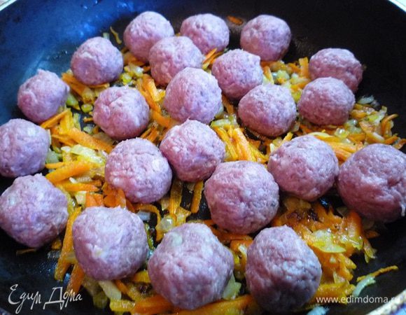 Лук и морковь перемешать, положить сверху фрикадельки и жарить в течении 20 минут, периодически помешивая.