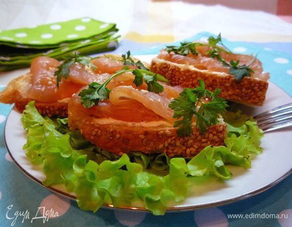 Уложить поверх масла куриную ветчину (нарезку), сбрызнуть лимонным соком и посыпать семенами кунжута. 