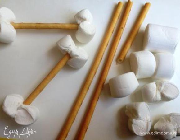 Соломку ломаем пополам. Маршмеллоу разрезаем вдоль пополам.
Можно каждую половинку скрутить в виде восьмерки и затем насадить на соломку с 2-х сторон.