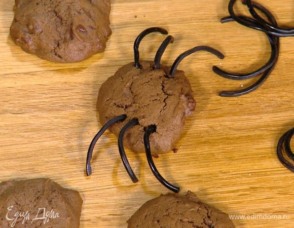 В часть горячего печенья по бокам воткнуть лакричные палочки, сделав из них ножки паучков.