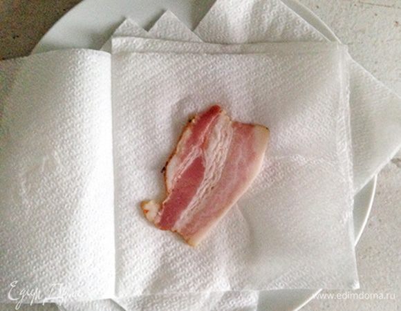 Бекон нарезаем на тонкие ломтики. Укладываем ломтики на тарелку, разделяя бумажными салфетками или бумажными полотенцами. Поверх последнего кусочка также кладем салфетки.

Они впитают лишний жир, защищая микроволновку от брызг жира.