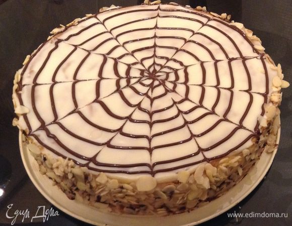 Достать торт из холодильника, покрыть ганашем (у меня был он в остатках). Для этого необходимо: подогреть сливки, вылить на кусочки шоколада, перемешать до однородности, покрыть торт заранее отложенным кремом с помощью корнетика. Нарисовать круги по спирали, быстро ножом или зубочисткой провести линии от центра и наоборот. Карл Шумахер использует помадку обычную и подкрашенное какао (вот выкладываю фото по оригинальному рецепту). Бока обсыпать миндальными лепестками или рубленными орехами.