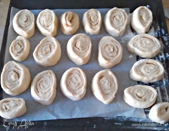 Подошедшее тесто выложить на присыпанный мукой стол, раскатать в пласт толщиной 0,5 мм, смазать растопленным маслом и присыпать смесью сахар с корицей. Свернуть в рулет, нарезать на булочки толщиной приблизительно 
2-3 см.