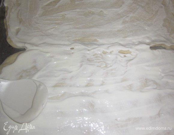 Тесто раскатать в пласт толщиной 1 см и намазать сметаной.