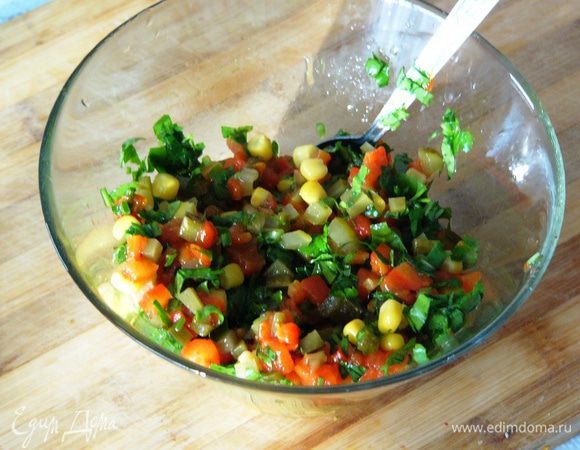 Смешать нарезанные овощи, зелень, кукурузу в отдельной миске, добавив немного оливкового масла. 