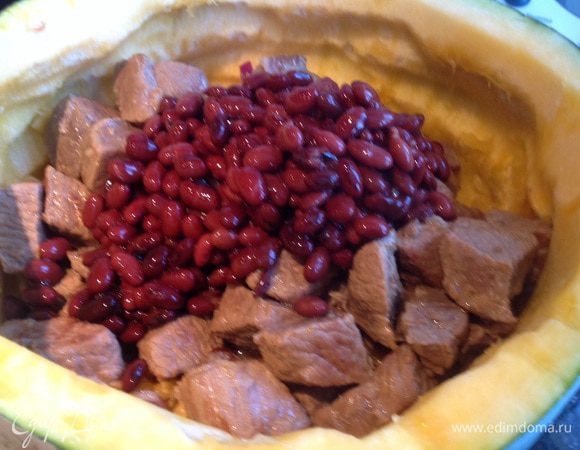 Выложите в тыкву лук, помидор, мясо (вместе с подливкой), фасоль (только слейте жидкость из банки).