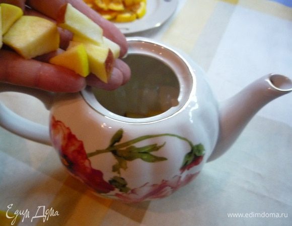 Чайник ополоснуть кипящей водой, положить в него яблоки, апельсины.