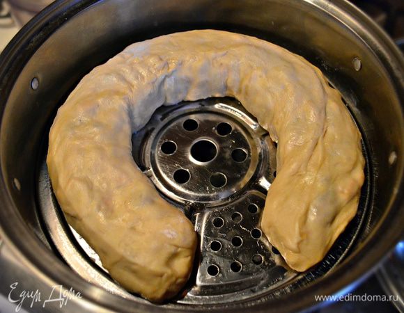 Один край пласта вместе с начинкой необходимо завернуть. Аккуратно заверните пласт с той же стороны ещё раз. Сверните, таким образом, пласт в не тугой рулет. Перенесите рулет в пароварку (донышко смажьте растительным маслом, чтобы тесто не прилипало). Готовьте ханум 50-60 минут.