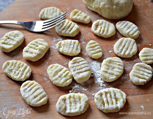 Пюре слегка остудите, добавьте половину муки и перемешайте. Затем выложите на рабочую поверхность присыпанную мукой, замешивайте тесто, оно не должно быть слишком мягким, иначе ньокки развалятся при варке. Из полученного теста сформируйте колбаски диаметром 1,5 см и разрежьте на кусочки по 2 см. Обваляйте слегка в муке и прижмите вилкой с обеих сторон. Отварите ньокки в кипящей подсоленной воде в течение 2 минут. Готовые ньокки выложите на тарелку и добавьте немного масла, чтобы они не склеивались друг с другом.
