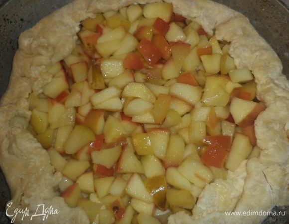 Охлаждённое тесто раскатать в круг толщиной 0,5 см. 
Выложить на него яблочную начинку, отступая от края на 1,5 см. Свободные края теста загнуть вверх.