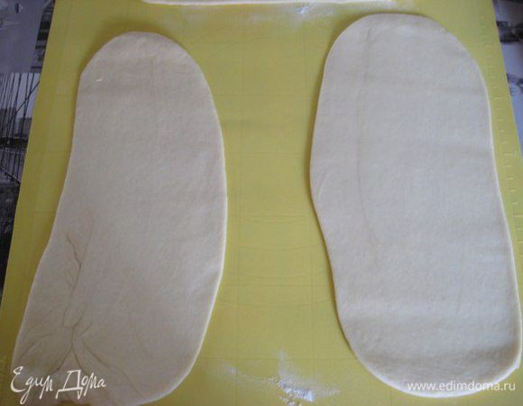 Тесто обмять, скатать тесто в цилиндр, разделить на 12 частей. Каждую часть раскатать в овал.