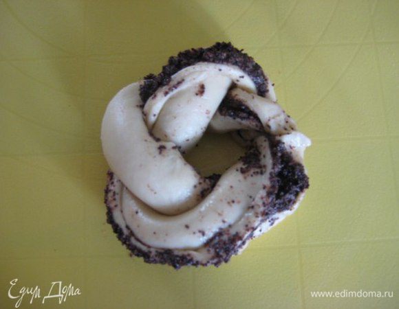 Сплести бублики, края закрепить с помощью белка. Разложить бублики на противне, накрыть полотенцем, оставить в тепле на 40 минут.