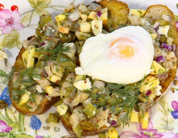 На обжаренный хлеб выложить селедочную начинку, сверху поместить оставшееся яйцо пашот и украсить веточками укропа.