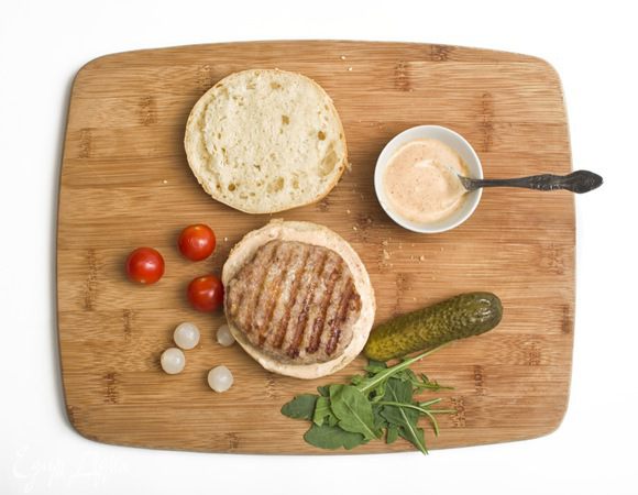 Майонез смешать с соусом чили. Булочки разрезать пополам. Смазать каждую половинку смесью майонеза и соуса чили. Затем на одну из половинок поместить котлетку и соединить половинки булочек.